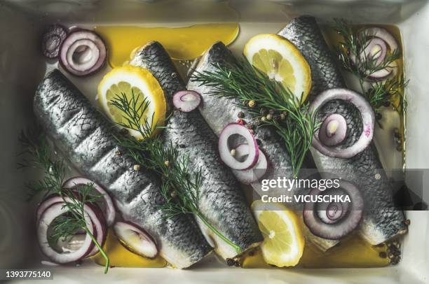 pickled whole herring with lemon, red onion, dill and oil. - salmuera fotografías e imágenes de stock