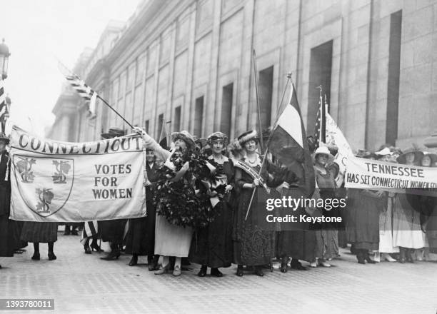 Women's suffrage activists holding banners reading 'Connecticut - votes for women' and 'Tennessee has set Connecticut women free' as they welcome...