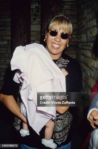 American songwriter Sandy Mahl holding her daughter, August Anna, backstage at Garth Brook's concert date at the Hollywood Bowl in Los Angeles,...