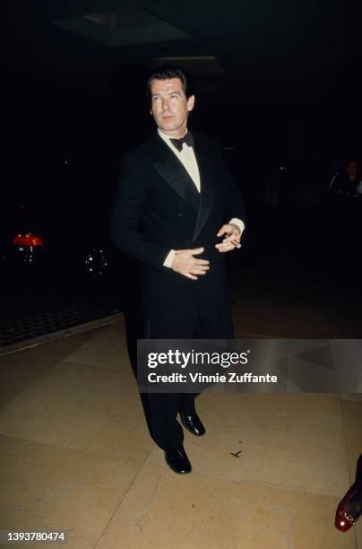 Irish actor Pierce Brosnan wearing a tuxedo and bow tie, and smoking a cigar, attends the 24th Annual American Film Institute Lifetime Achievement...