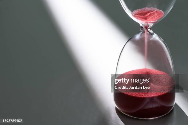 hour glass with a focus light source - sanduhr stock-fotos und bilder