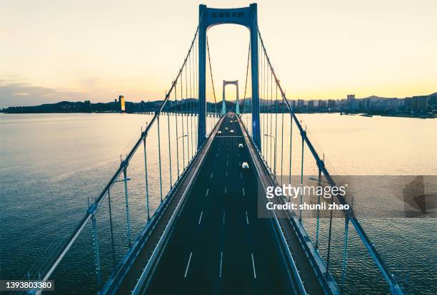 aerial view of cross-sea bridge at sunset - pont à haubans photos et images de collection