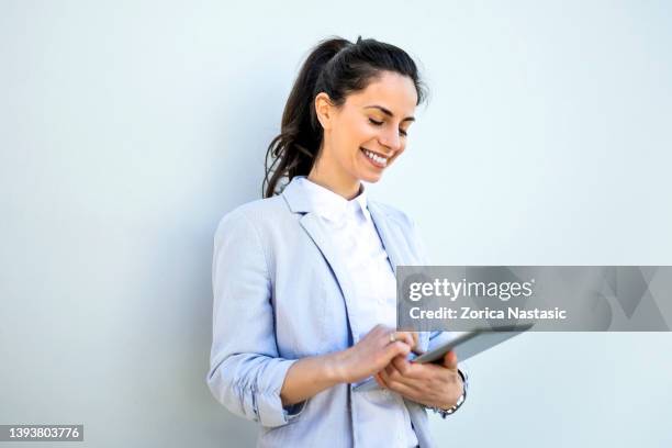 portrait of a young businesswomen standing isolated over white background using digital tablet - indian corporate women background stockfoto's en -beelden