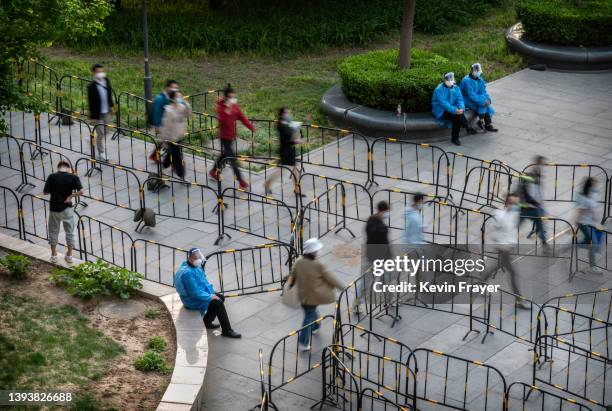 Employees from local high-tech companies and others arrive to take nucleic acid tests to detect COVID-19 at a makeshift testing site in Haidian...