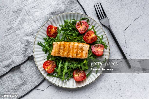 roasted salmon with arugula and tomatoes - low carb diet - fotografias e filmes do acervo