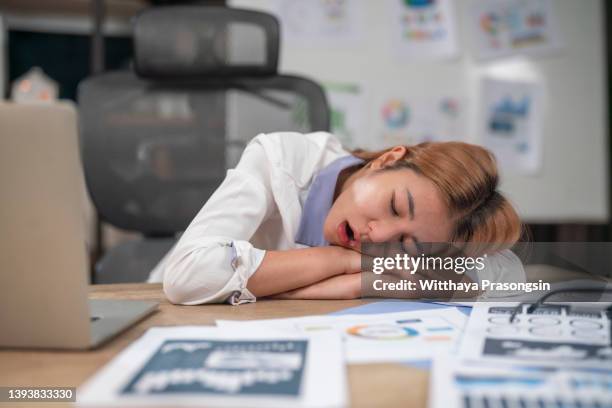 woman falling asleep at work desk - monday stock-fotos und bilder