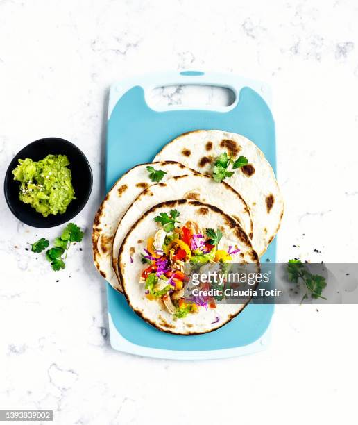 chicken tacos on cutting board on white, marble background - chopped tomatoes foto e immagini stock