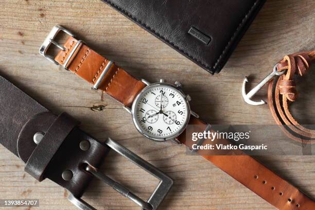 flat lay photo of macho vintage wristwatch with leather wallet belt and manly arm band with anchor design - casual menswear stock pictures, royalty-free photos & images