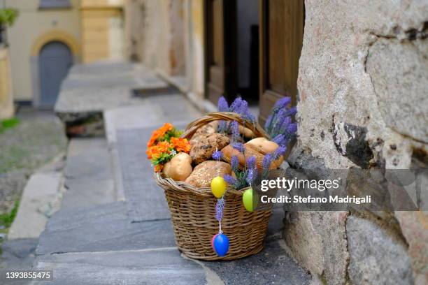 wicker basket with colorful flowers and bread - happy easter in italian stock pictures, royalty-free photos & images