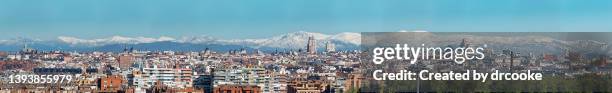 very wide panorama of the city of madrid with snow covered mountains in the background - madrid panorama stock pictures, royalty-free photos & images