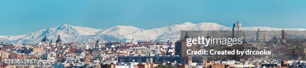 very wide panorama of the city of madrid with snow covered mountains in the background - madrid snow stock pictures, royalty-free photos & images