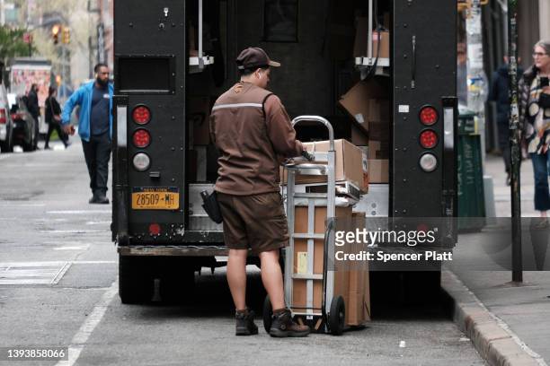 United Parcel Service worker delivers boxes in Manhattan on April 26, 2022 in New York City. The Atlanta-based courier announced that revenue rose...
