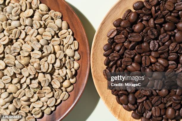 raw coffee beans vs. roasted coffee beans - rohe kaffeebohne stock-fotos und bilder