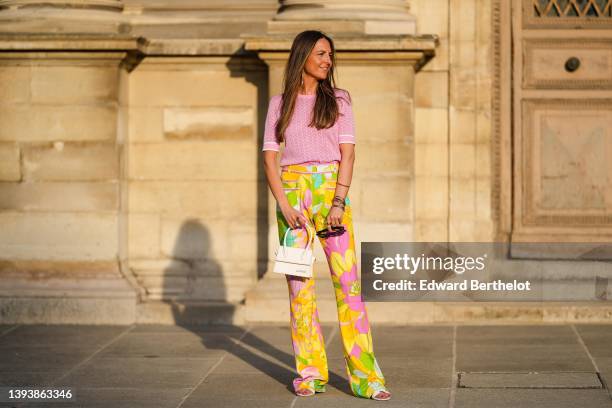 Alba Garavito Torre wears black sunglasses from Ray Ban, gold earrings, a pale pink cut-out pattern short sleeves t-shirt Leonard Paris, high waist...