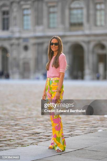 Alba Garavito Torre wears black sunglasses from Ray Ban, gold earrings, a pale pink cut-out pattern short sleeves t-shirt Leonard Paris, high waist...