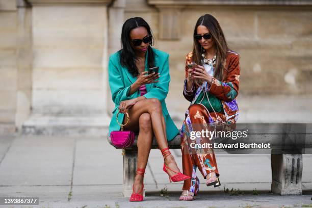 Alba Garavito Torre wears black sunglasses from Ray Ban, gold earrings, a large white pearls / gold chain and black ribbon necklace, a white t-shirt,...