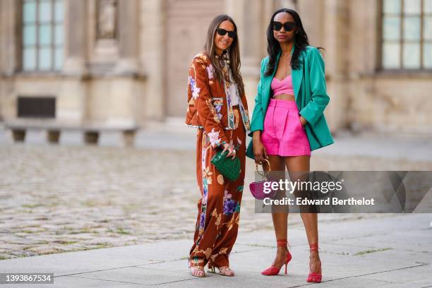 Alba Garavito Torre wears black sunglasses from Ray Ban, gold earrings, a large white pearls / gold chain and black ribbon necklace, a white t-shirt,...