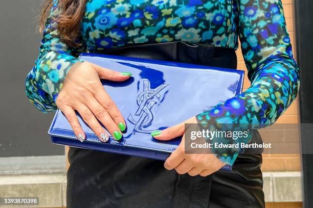 Samia Laaboudi wears a black with pale blue / gray / royal blue flower print pattern turtleneck / long sleeves t-shirt from Ganni, a black shiny...