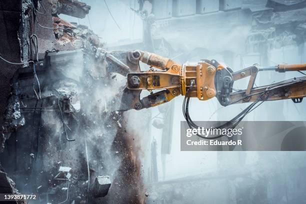 mechanical digger demolishing building. - crane construction machinery foto e immagini stock