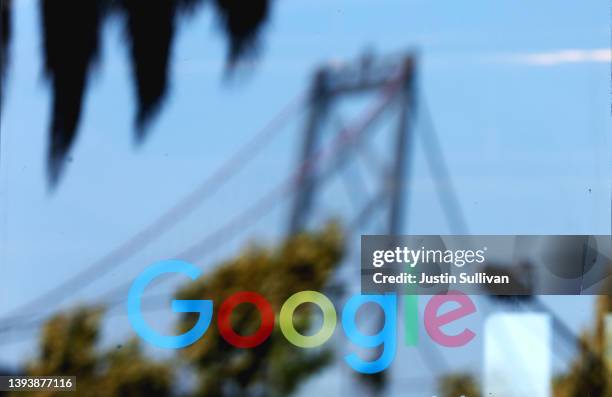 The San Francisco Bay Bridge is seen reflected on the entrance to a Google office on April 26, 2022 in San Francisco, California. Google parent...