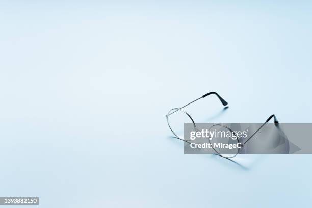 round eyeglasses on light blue background - occhiali da vista foto e immagini stock