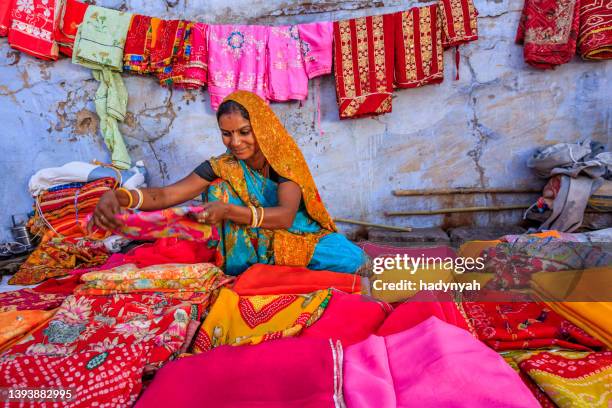 colors of india - woman selling colorful fabrics on local bazaar - sari 個照片及圖片檔