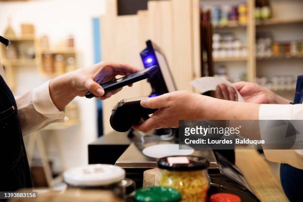 contactless payment with smartphone at the point of sale - digital payment stock-fotos und bilder