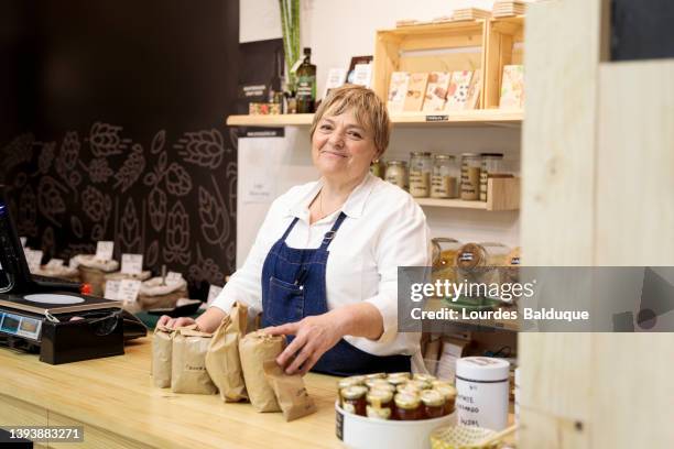 woman working in an organic store - mini grocery store photos et images de collection