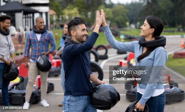 happy go-cart drivers high-fiving after a race - go cart imagens e fotografias de stock