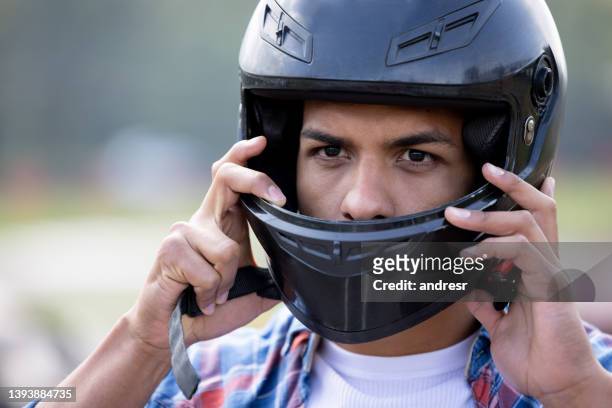 hombre poniéndose el casco y preparándose para correr en los go-carts - crash helmet fotografías e imágenes de stock