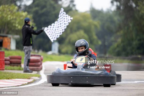 man racing in go-carts and crossing the finishing line - the ride of champions stock pictures, royalty-free photos & images