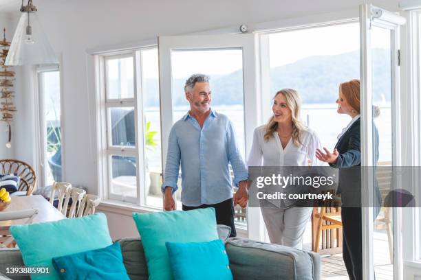 real estate agent showing a mature couple a new house. - travel real people stockfoto's en -beelden