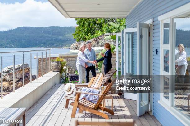 real estate agent showing a mature couple a new house. - real estate agent stock pictures, royalty-free photos & images