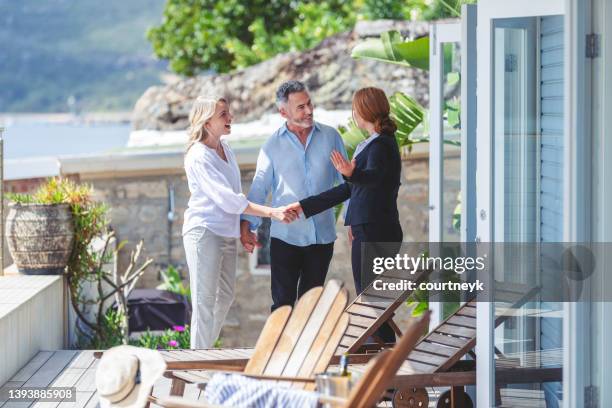 real estate agent showing a mature couple a new house - real estate agent imagens e fotografias de stock