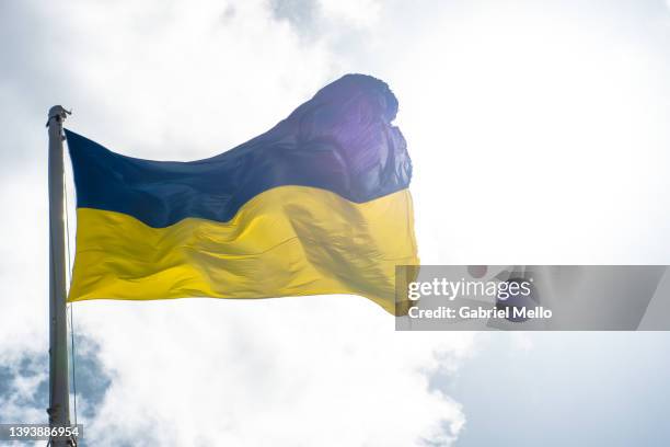 ukrainian flag flying against cloud sky - bandeira-da-ucrânia imagens e fotografias de stock