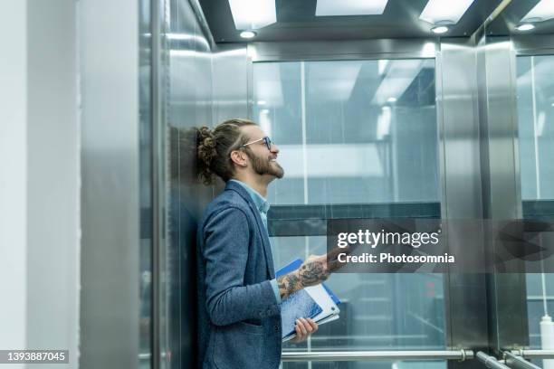 empresario en ascensor. - ascensor fotografías e imágenes de stock