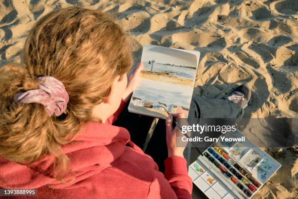 woman sitting and painting on a beach - art passion stock pictures, royalty-free photos & images