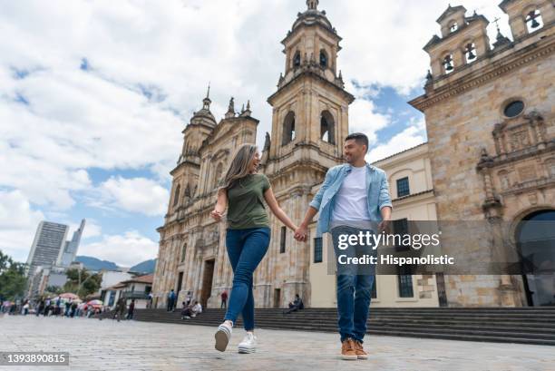 coppia felice che si tiene per mano durante la visita a bogotà - bogota foto e immagini stock