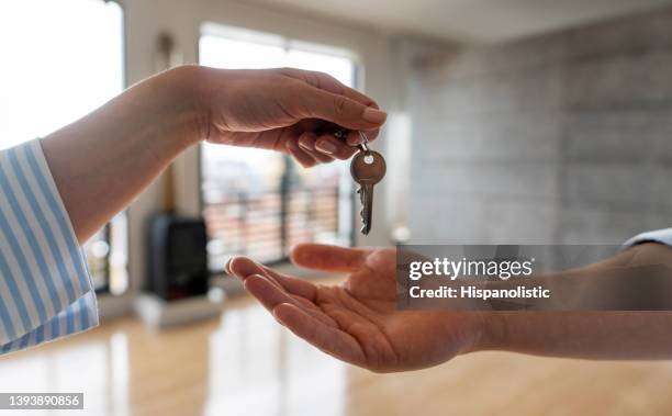 immobilienmakler übergibt einem mann die schlüssel seines neuen hauses - wohnung stock-fotos und bilder