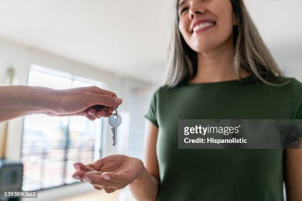 immobilienmaklerin gibt die schlüssel ihres neuen hauses an eine glückliche frau - agent and handing keys stock-fotos und bilder
