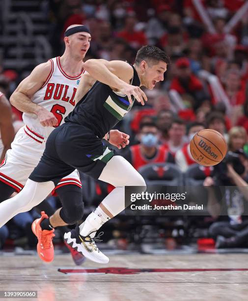 Grayson Allen of the Milwaukee Bucks chases down the ball under pressure from Alex Caruso of the Chicago Bulls during Game Four of the Eastern...