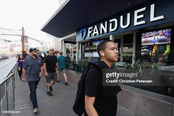 Fans walk past a Fanduel sports betting location at Footprint Center before Game Five of the Western Conference First Round NBA Playoffs between the...