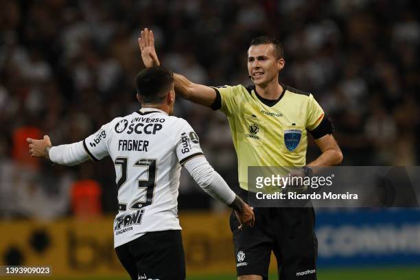 Referee Andres Matonte argues with Fagner of Corinthians after showing him a yellow card during a match between Corinthians and Boca Juniors as part...
