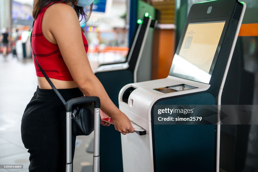 Automated Check In Counter Businesswoman Using Automated Check In Machine At Airport High-Res ...