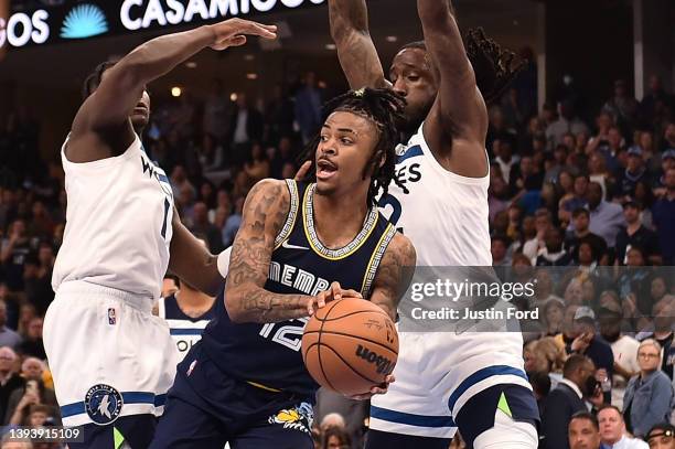 Ja Morant of the Memphis Grizzlies looks to pass against Anthony Edwards and Taurean Prince of the Minnesota Timberwolves during Game Five of the...