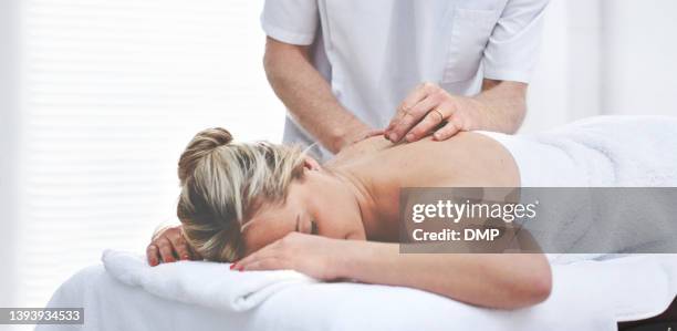 una giovane donna che ottiene aghi inseriti nella schiena durante una sessione di agopuntura. un paziente che riceve una terapia alternativa per il trattamento medico - trattamento di bellezza foto e immagini stock