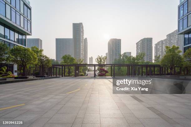 empty parking lot in front of modern building - glass building road stockfoto's en -beelden