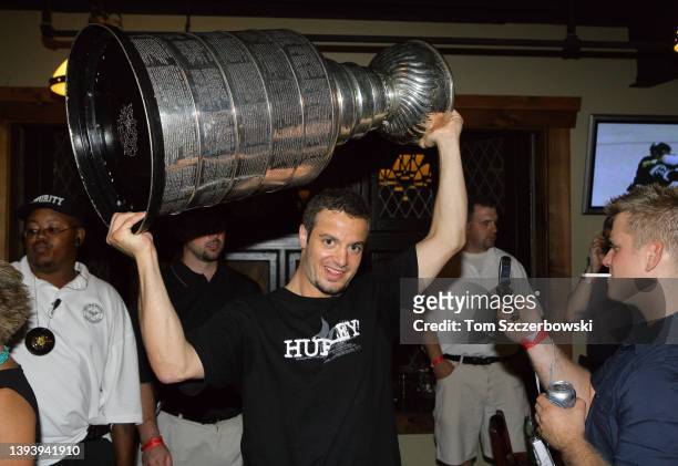 Chad LaRose of the Carolina Hurricanes celebrates as he holds up the Stanley Cup at Cheli's Chili Bar restaurant during his day with the Cup after...