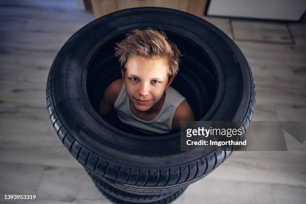 adolescente jugando con neumáticos en el moderno hall del apartamento - flat tire fotografías e imágenes de stock