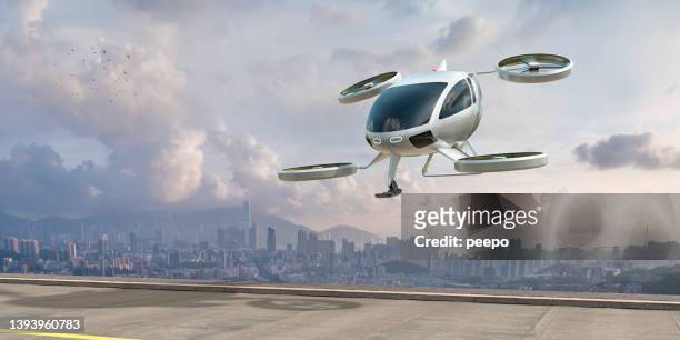 evtol electric vertical take off and landing aircraft in procinto di atterrare vicino alla città - drone foto e immagini stock